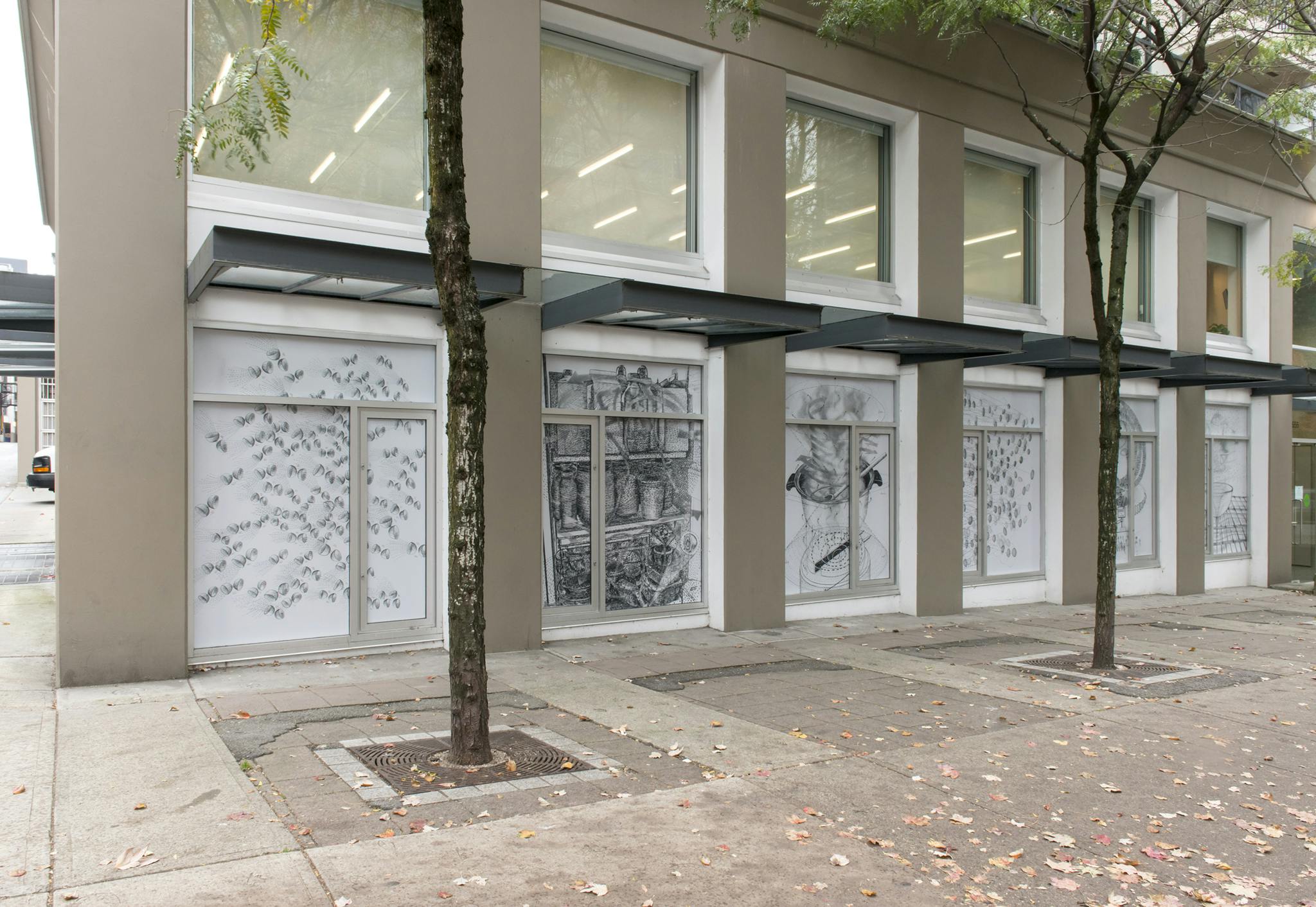 Exterior image of CAG with the work of Ingrid Koeing installed on the ground floor facade windows. Six windows display six, large-scale vinyl prints of back and white graphite drawings. 