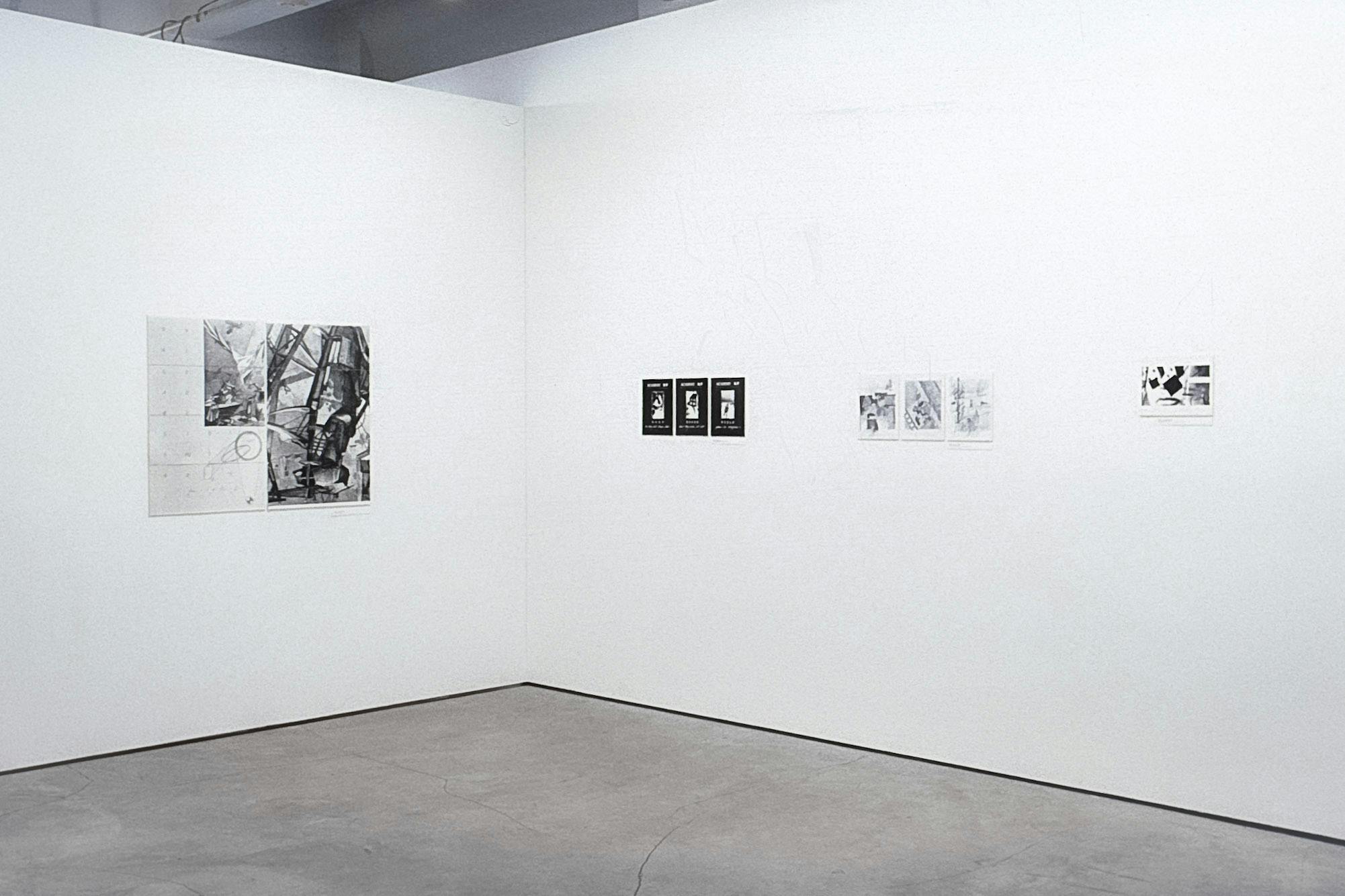 4 different artworks are on the walls of a gallery. One is made of a large black and white photo of metal architecture and text. The others are smaller and include different black and white photos.
