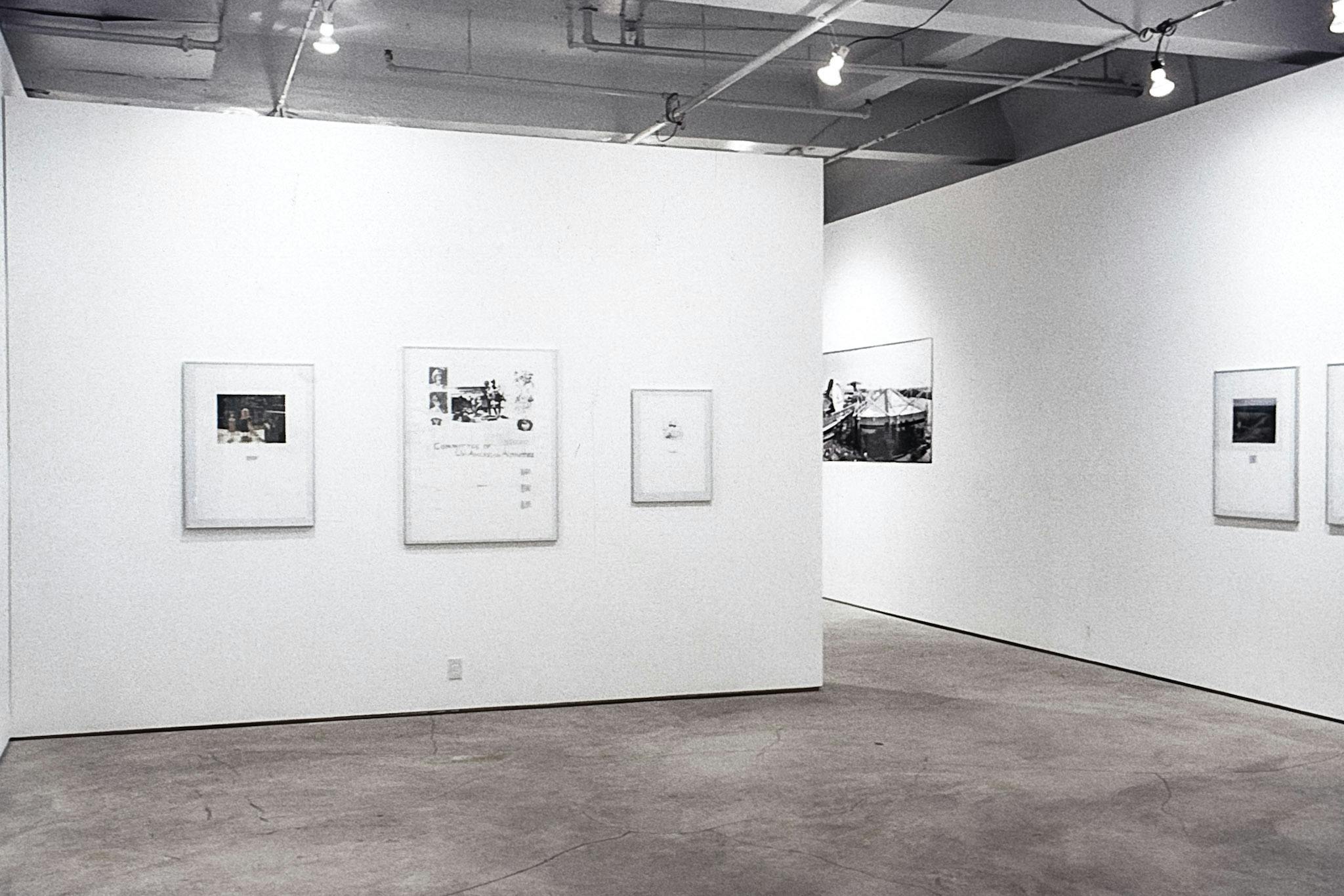 Different-sized illustrations and collages are in metal frames mounted on the white walls.