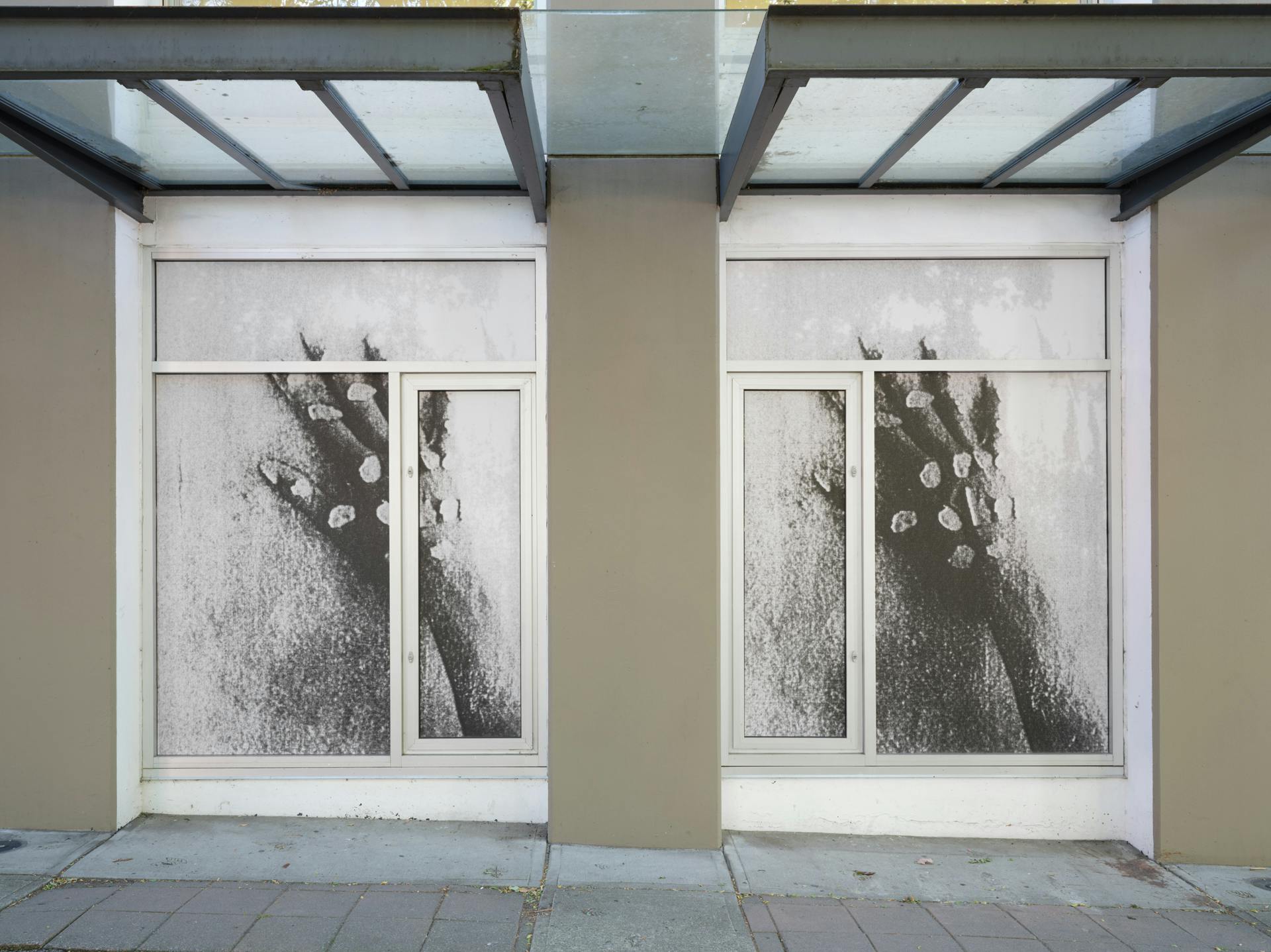 A pair of windows featuring a pair of images depicting a hand with small white pebbles placed on its joints. Both images are darker than is optimum, with the right image darker than the left one.