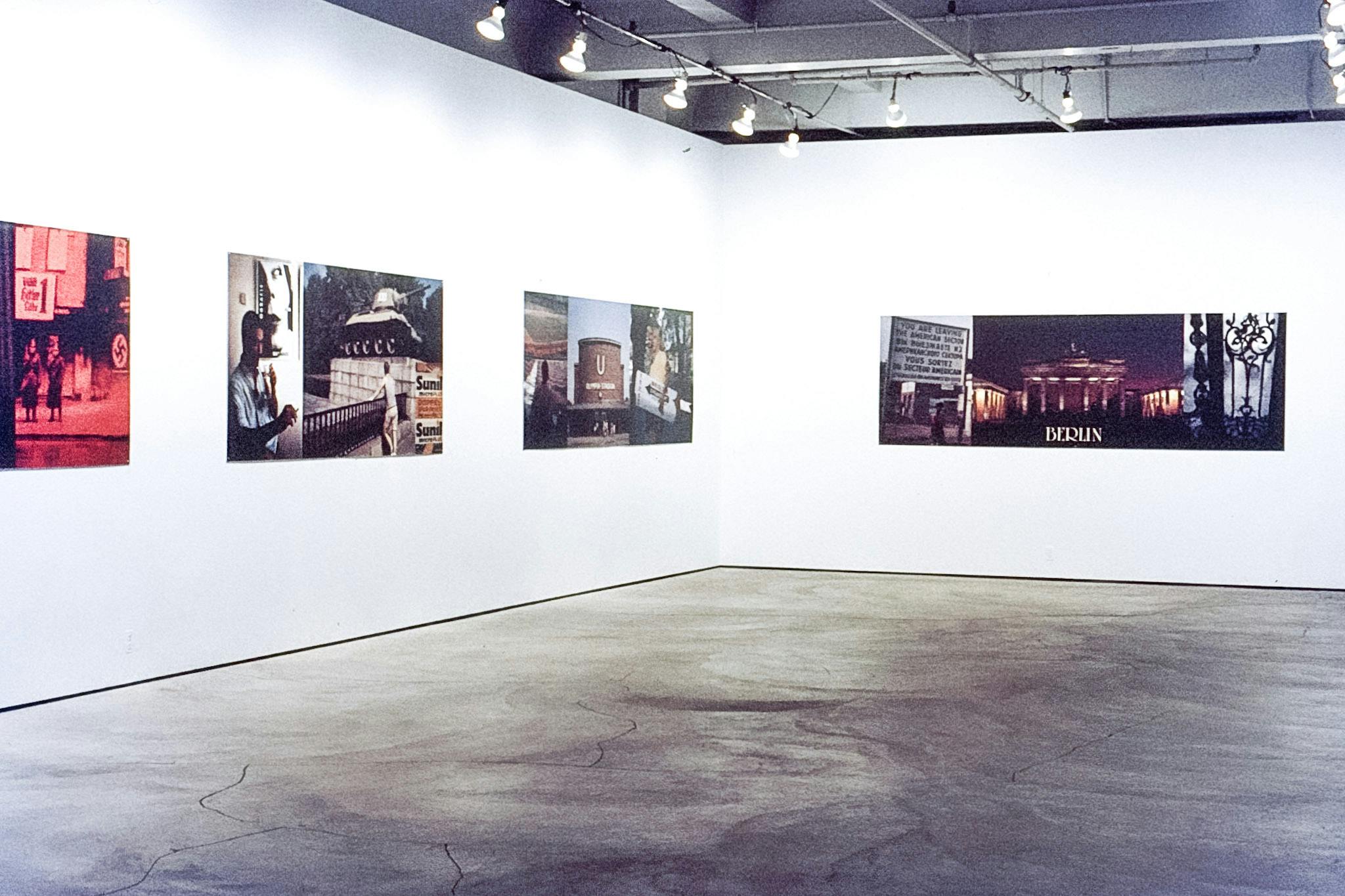 Four horizontal works spread across two gallery walls. The works each have 2 or three photos in them. The photos include a rec-coloured image of Nazi Germany, a baseball field, and a metal gate.