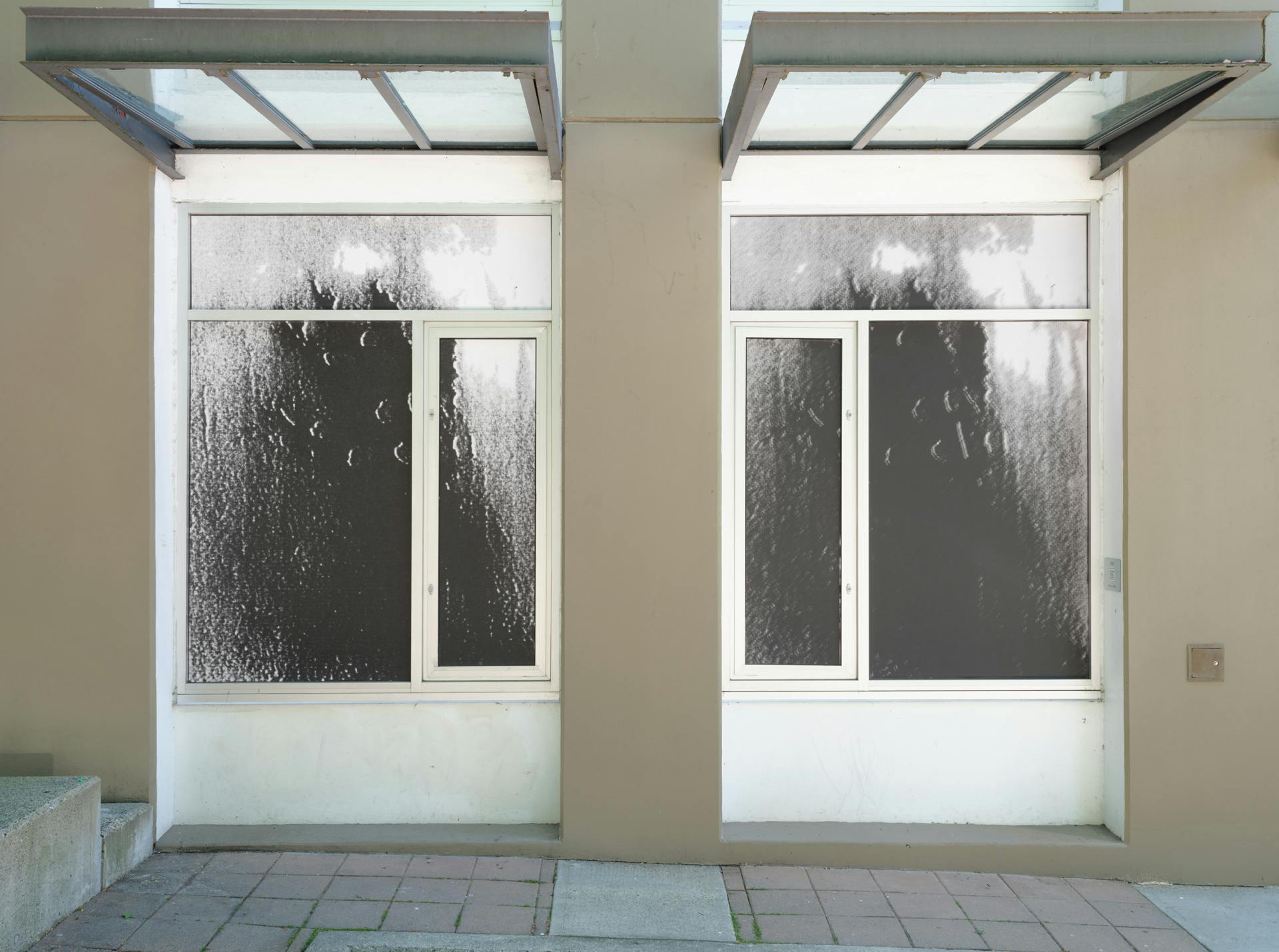 A pair of windows featuring what look like black smudges or shadows. The right image is slightly darker than the left one.