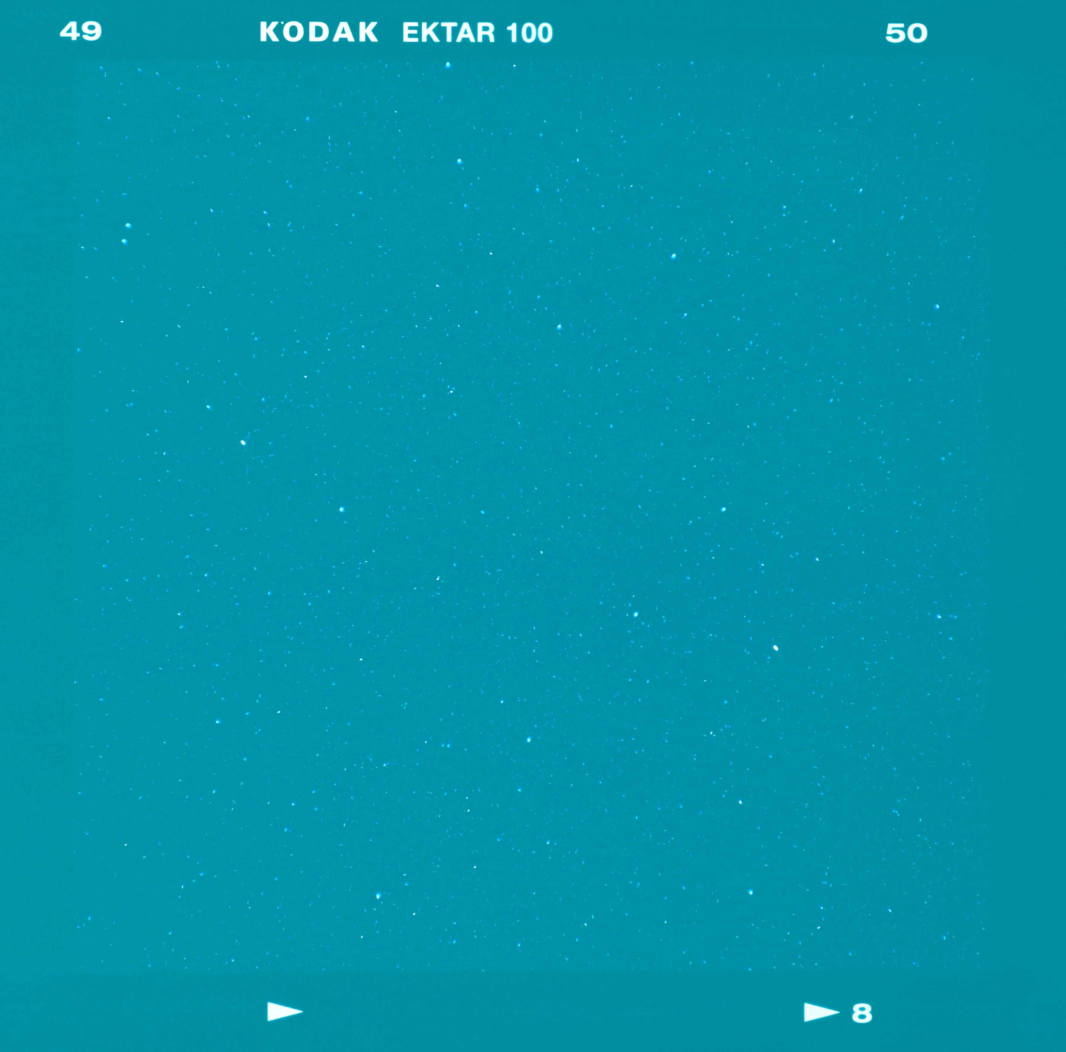 A square of turquoise blue with a smattering of white specs resembling a starry sky. White text at the top reads “49 KODAK EKTAR 100 50.” 