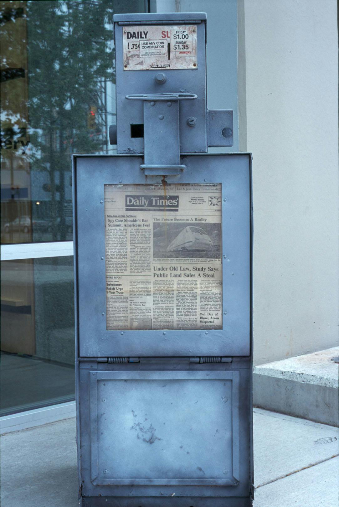 A metal made newspaper dispenser sits outside of the CAG’s front entrance. This silver coloured machine looks worn and contains a yellowed paper called Daily Times.