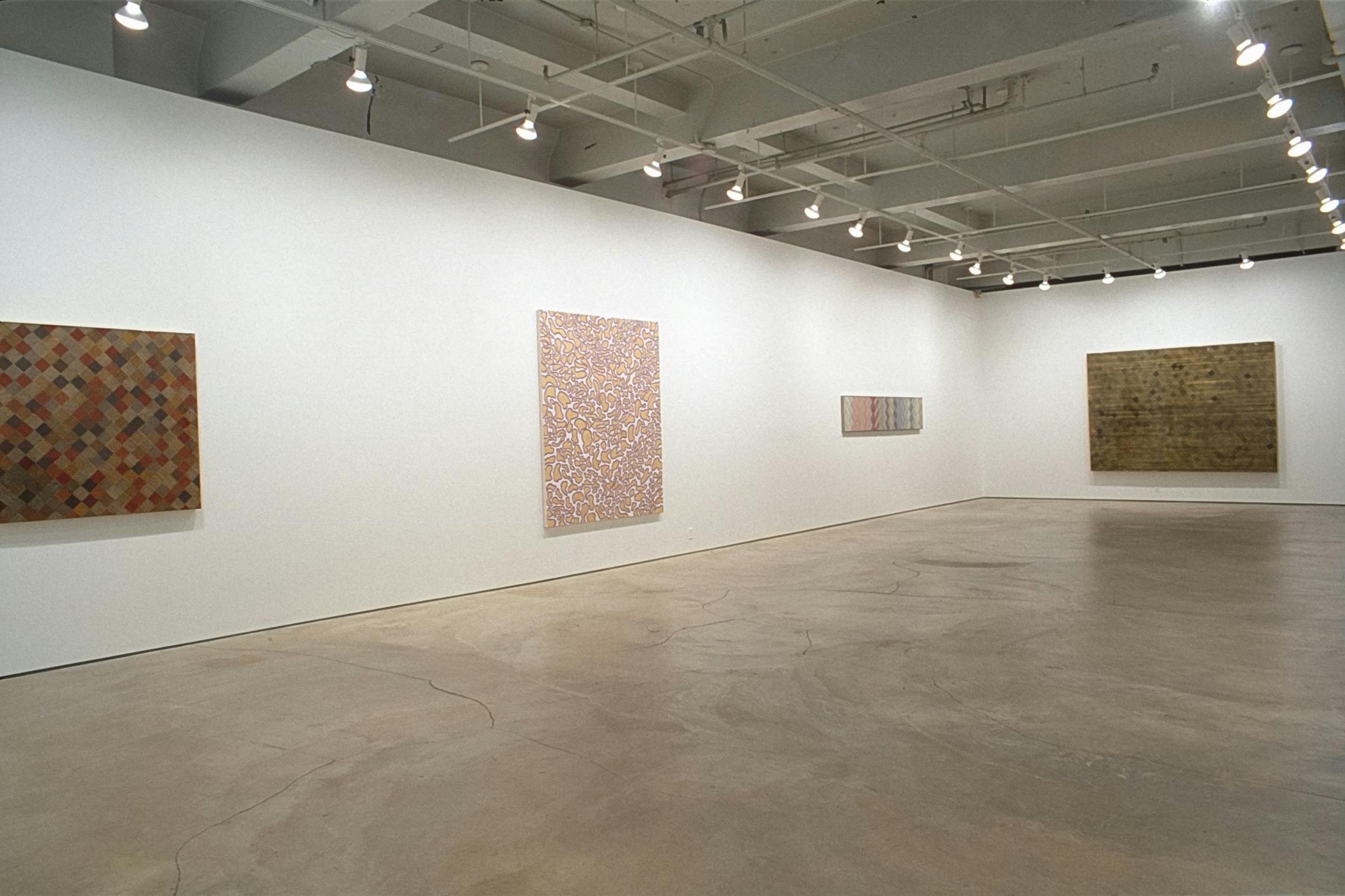 Four abstract paintings of various sizes are installed on the gallery walls. Two of them are painted in a brown colour scheme. Two paintings in the middle share a similar pink  color.