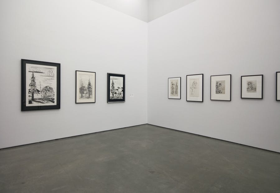 Seven framed works on paper mounted on a gallery wall. Three artworks hang on the left side of a corner wall and four on the right. The artworks depict various renderings of trees and human figures.