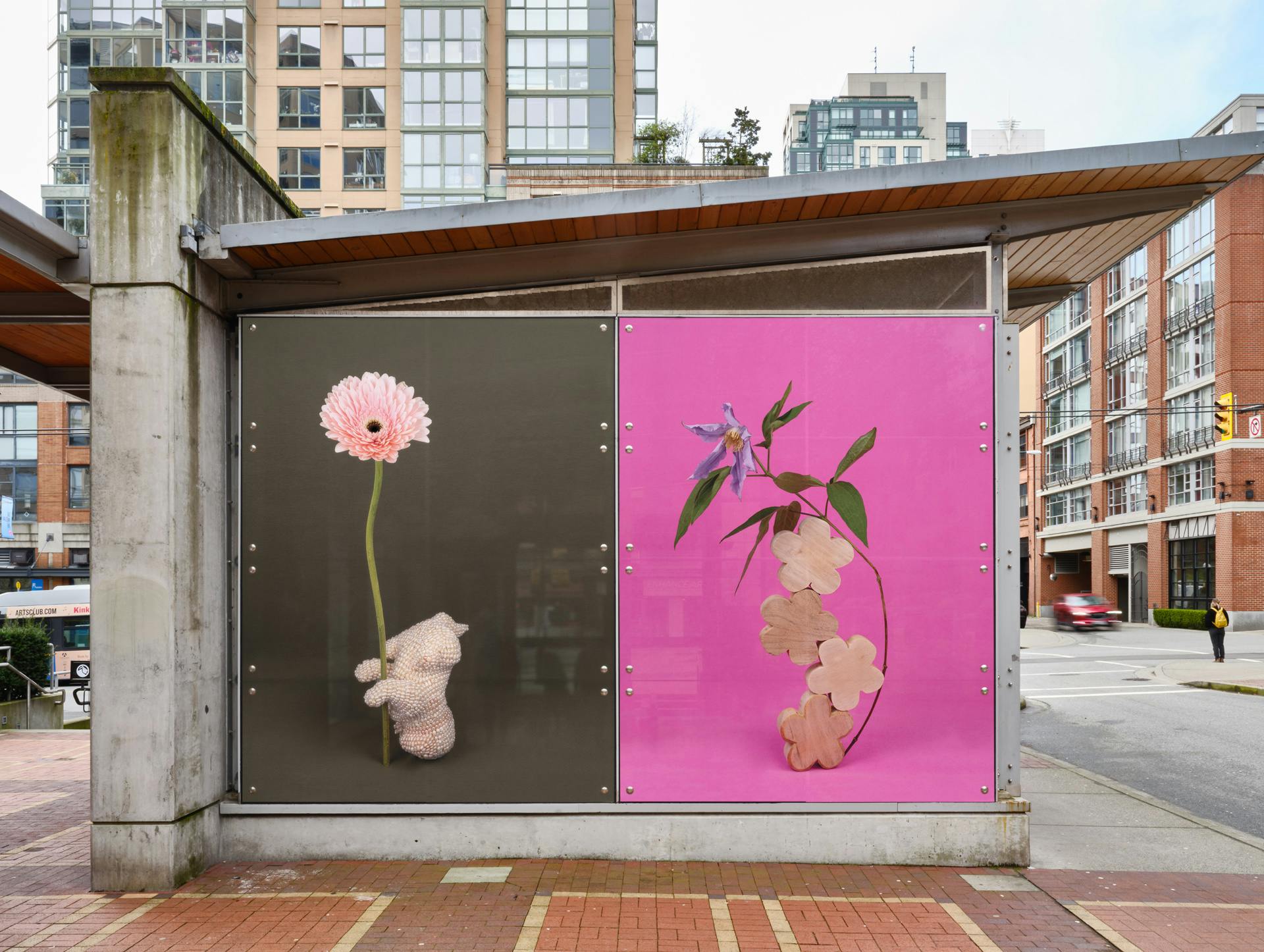 Two large-scale still life photographs printed in vinyl cover an entire side of Yaletown-Roundhouse station. The images depict singular flowers with various objects on pink and brown backgrounds. 