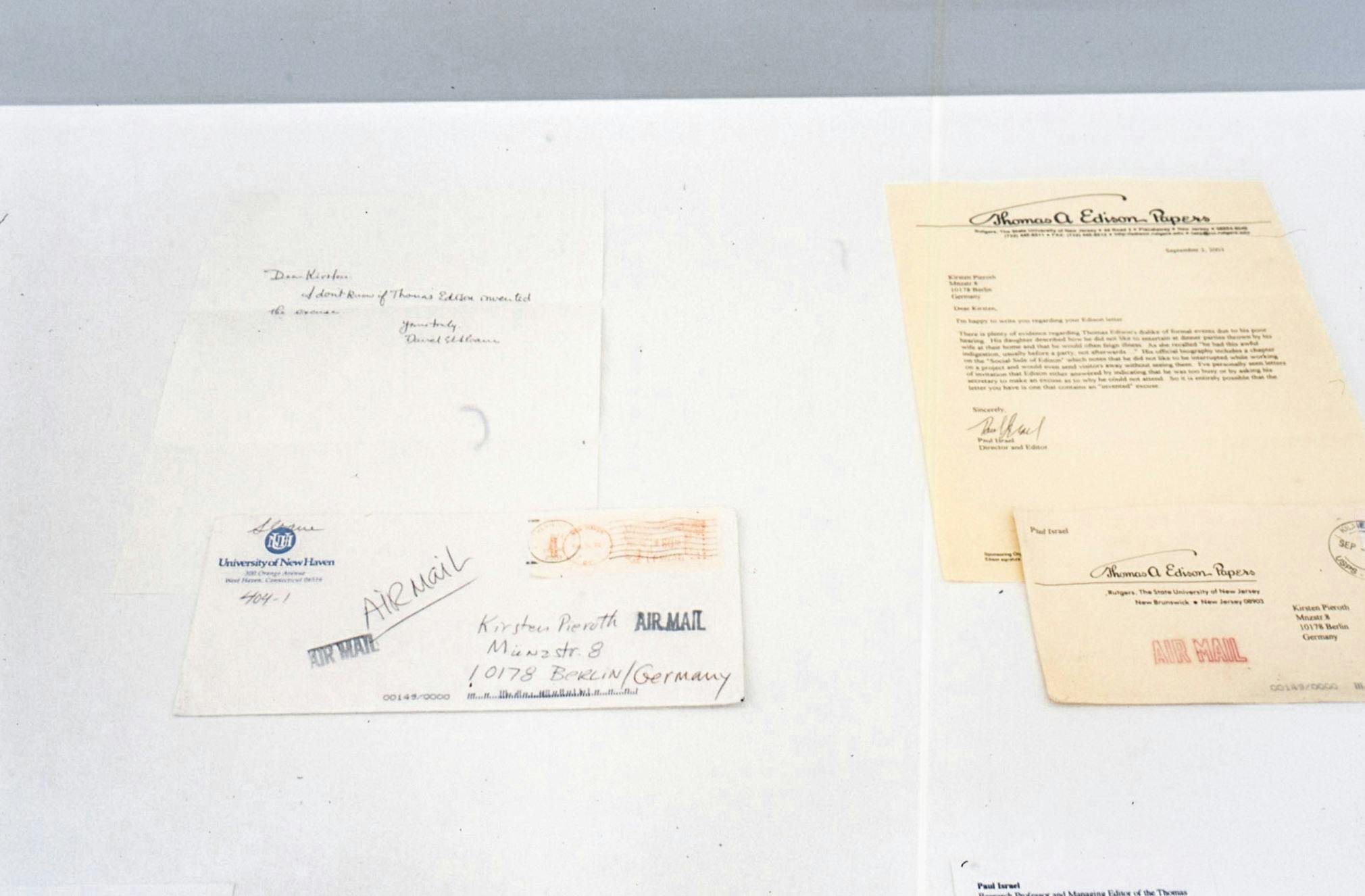 Detail of an installation. In a display case, two sets of a letter and an envelope are exhibited. Both letters were sent to the artist Kirsten Pieroth. The letter on the left is handwritten and the one on the right is typed.