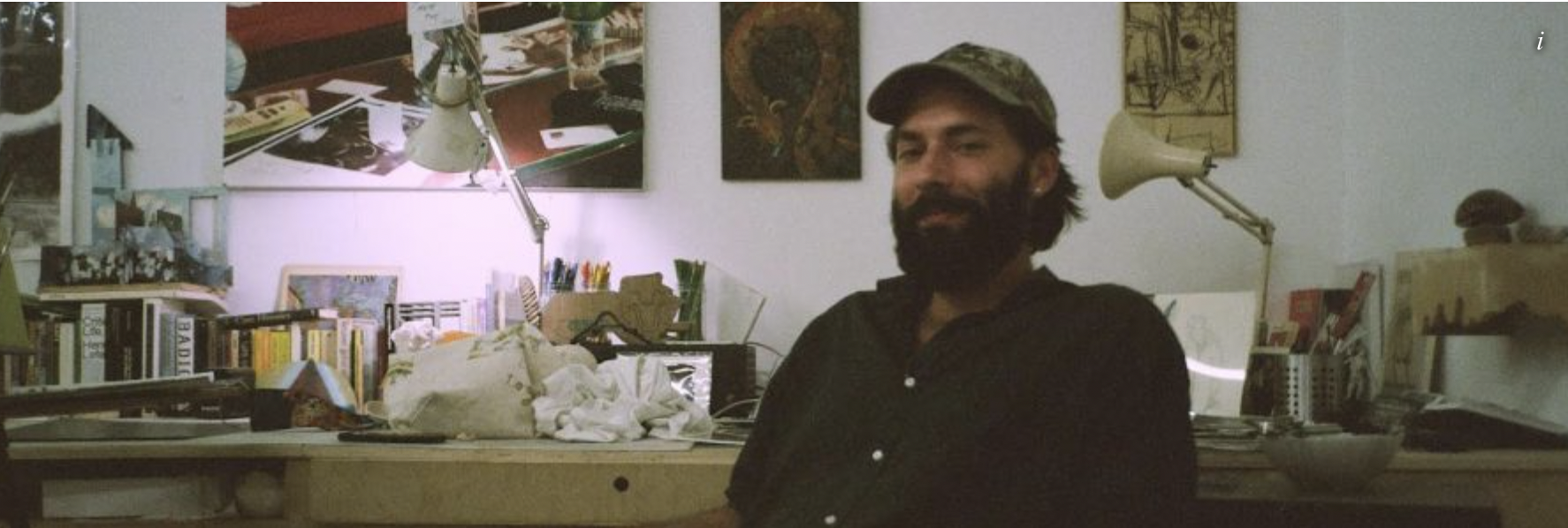  A still image of Tristan Unrau sitting by his desk in his studio. 