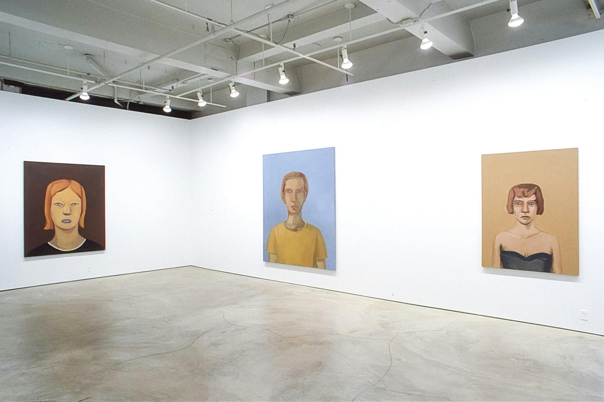 Three portrait paintings are exhibited on the galley walls. The left one is a woman in a brown background, the middle one is a man in a blue background. The one on the right is a woman in black.