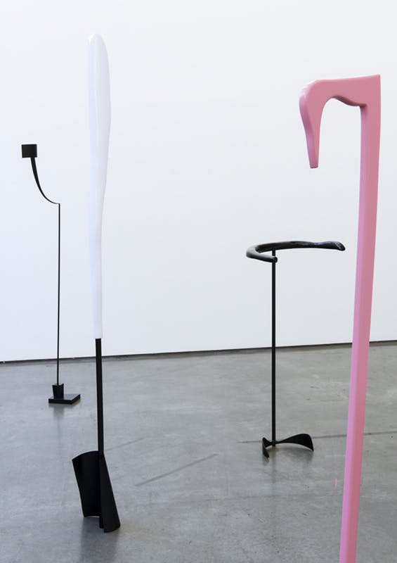Nairy Baghramian's sculptures installed in a gallery  Some of the black and white sculptures are larger than human-scale. Their rounded heads are supported by thin straight necks.
