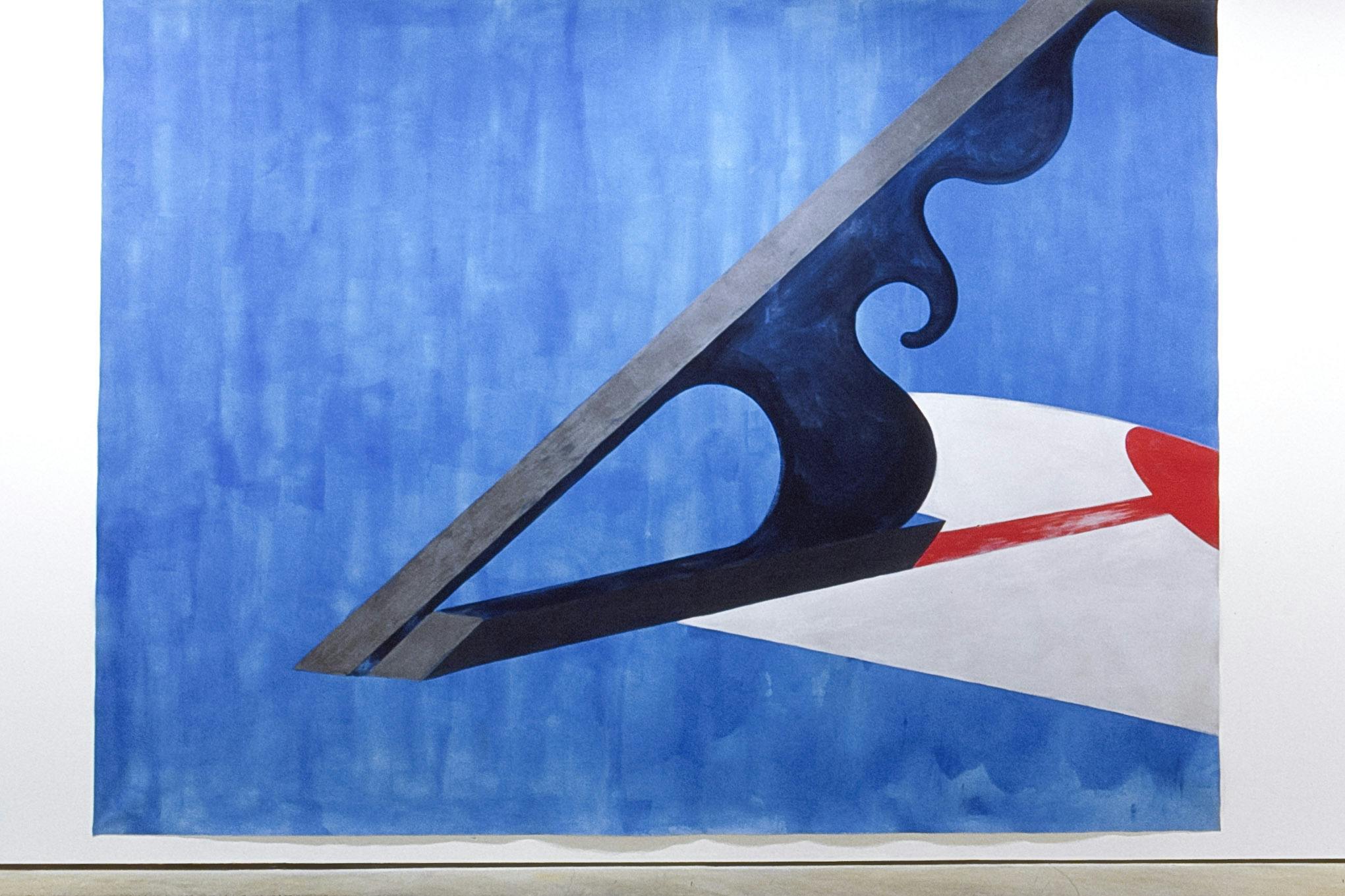 A large painting is installed in the gallery. In the sky-blue background, two gray straight lines form a sharp angle. A navy-coloured shape resembling melting metal is drawn in between the two lines. 
