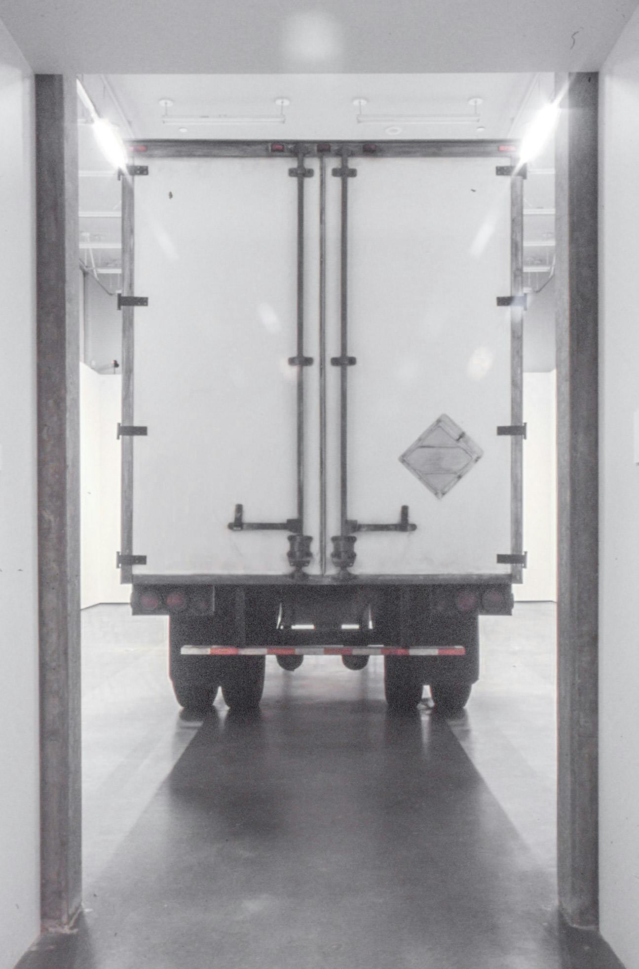 This is the installation shot of Geoffrey Farmer’s exhibition at CAG. A large white semi truck trailer is installed in a gallery space. The trailer is placed to face its back to the gallery entrance.