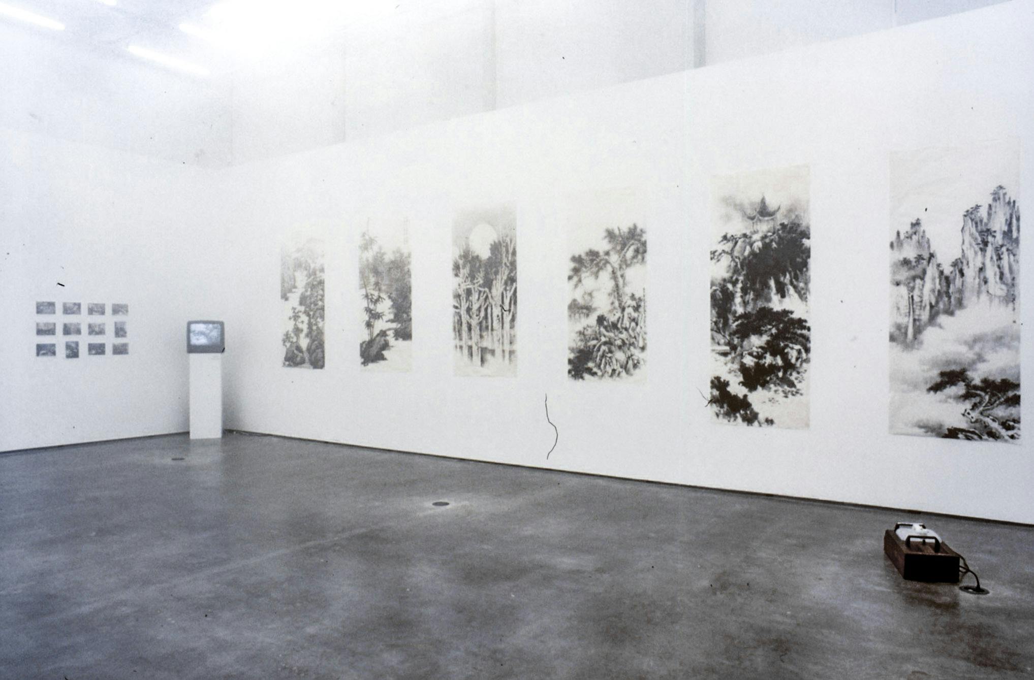 This is an installation shot of Cai Guo Qiang’s solo exhibition at CAG. This show includes black hanging scroll paintings, photographs, a video work, and a sculpture. 