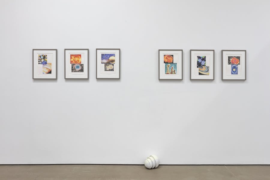 Six collage pieces are installed on the gallery wall. Each piece has two photographs of planets and stars in saturated colours. A white ceramic sculpture is placed on the floor beneath the collages. 