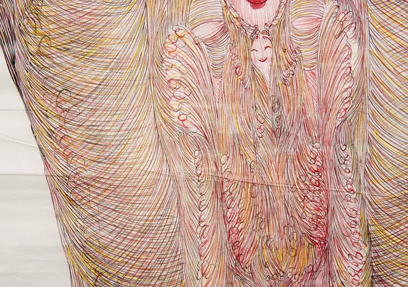 Detail image of a drawing by Guo Fengyi. A collection of repeating, hand-drawn lines of warm colours creates a dense, feather-like pattern on paper. A small face is visible in the middle.