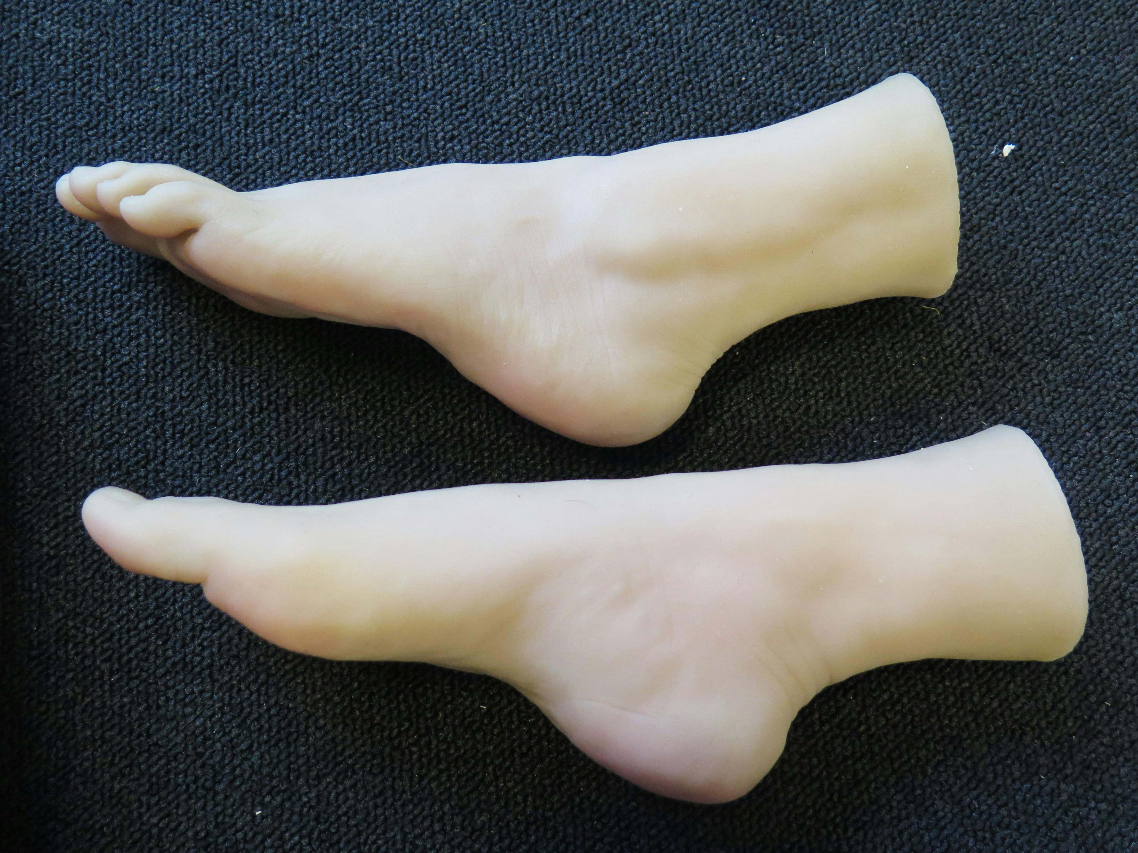 A photograph of a pair of prostheses feet placed on black fabric. 
