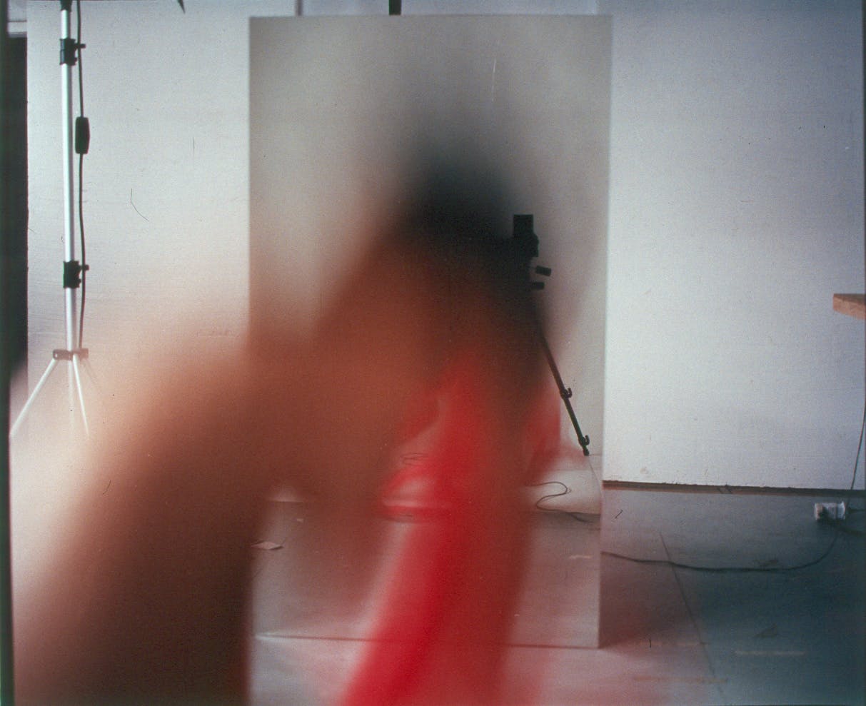 A photograph of an interior photo studio. Most of the image is obscured by an indiscernible blurred shape in the foreground. 