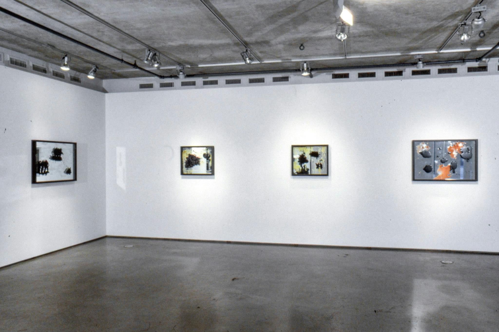 Installation image of Marina Roy’s paintings. Paintings of abstract shapes are made on the mirrors. Three paintings are mounted on the far wall and a larger painting on the left wall. 