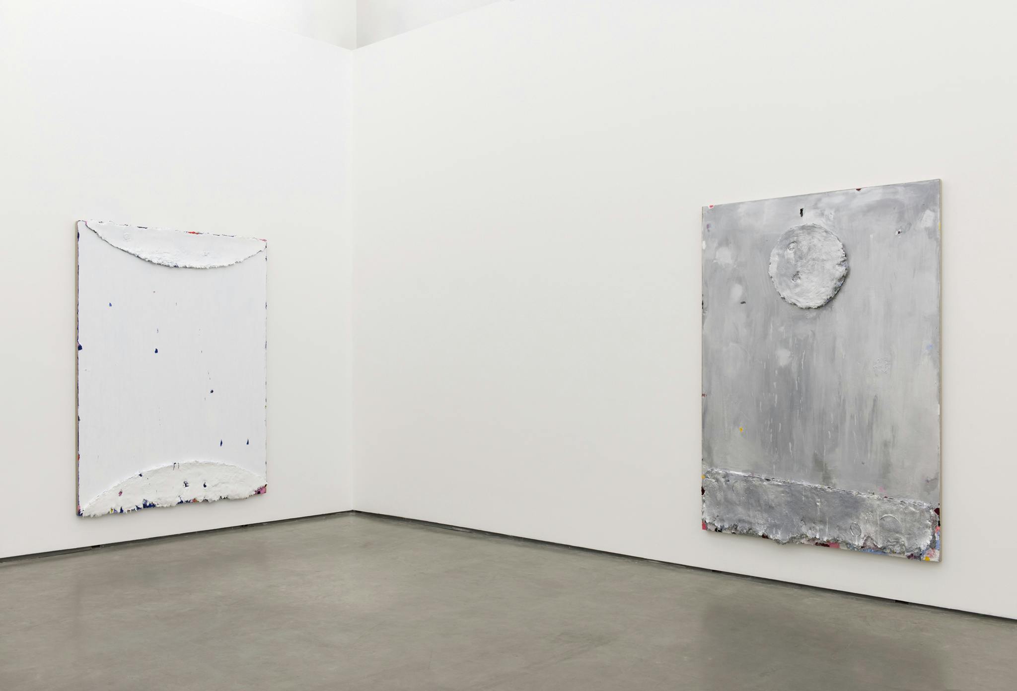 Two large-scale paintings hang on the ether side of a corner wall of a gallery space. The paintings appear sculptural, through the process of repeated layering and manipulating of the paint. 