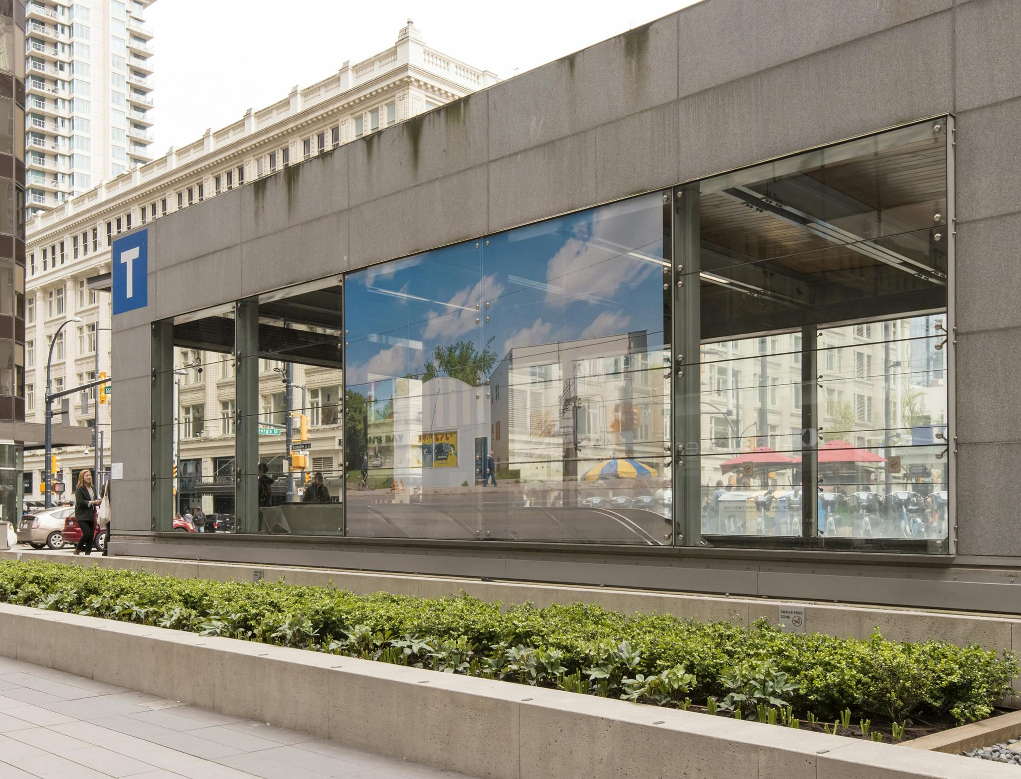 Exterior image of Yaletown Roundhouse Station with a large-scale photograph installed on the facade. The photograph depicts a small-town Saskatchewan streetscape with its signage in Cree syllabics.