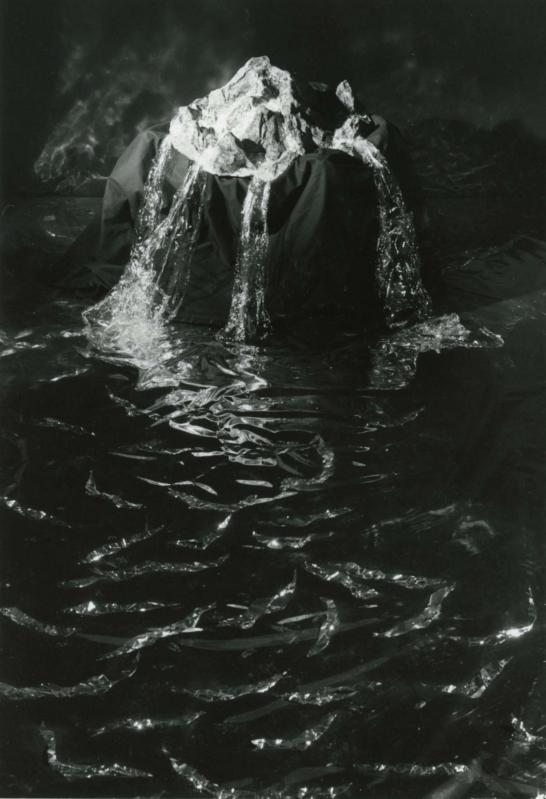 An abstract black and white photograph depicting rock and water-like forms. 