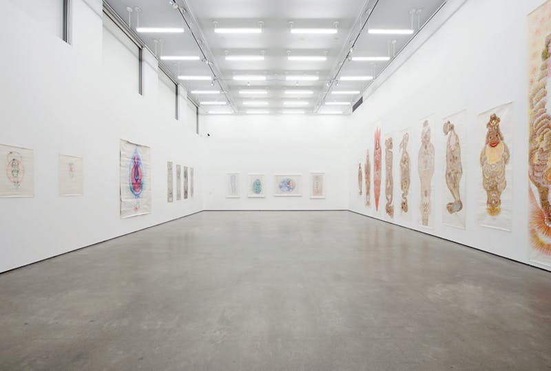Multiple drawings by Guo Fengyi installed on white gallery walls. Four, white-framed drawings in colour are mounted on the back wall while large-scale drawings on paper hang on the left and right walls.