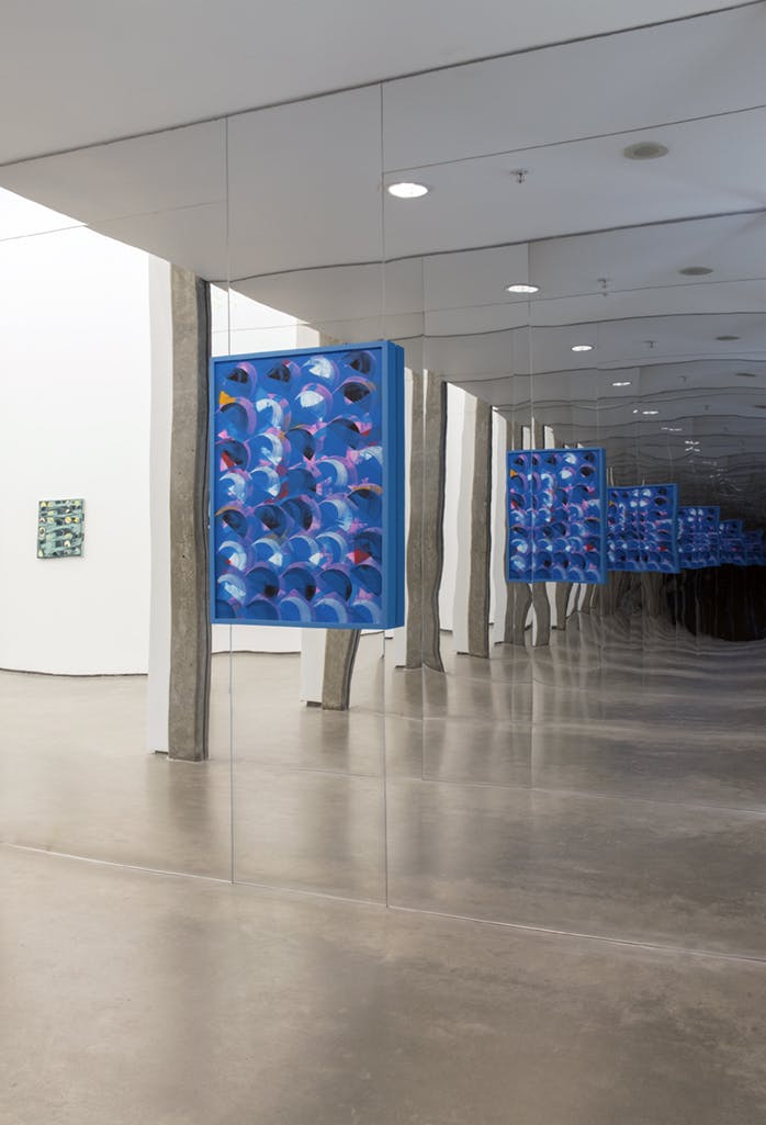A blue, abstract painting is installed in a gallery hallway. Both walls are covered in mirrored panels, creating infinitely repeating reflections of the painting to recede into the mirrors opposite. 