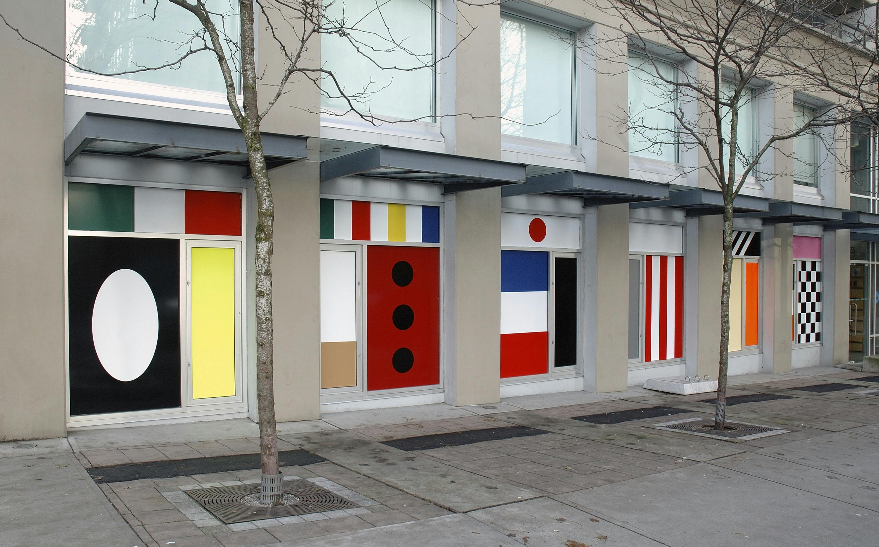 Install image of the first floor windows of CAG facing Nelson Street. Vinyl sheets of many patterns in various bold colours cover the windows.