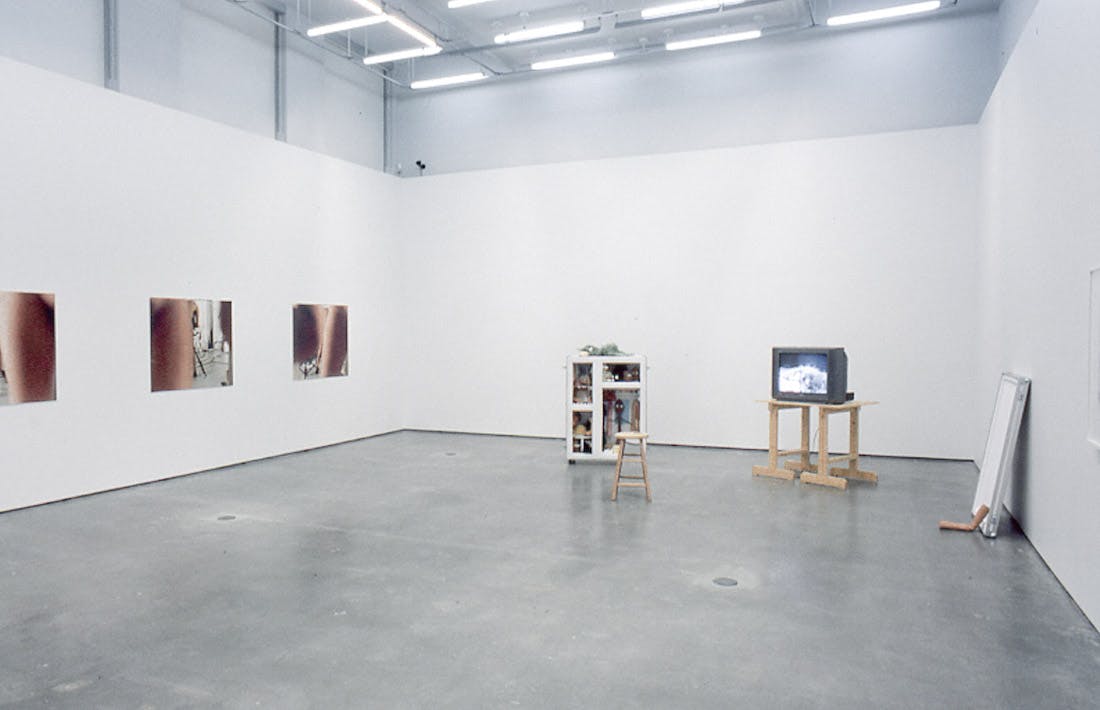 This is an installation shot of a gallery space. A set of three photographs are installed on the left wall. Some sculptural installations are placed in the far right corner of the room. 